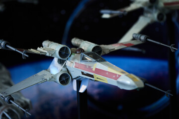 Naklejka premium A fleet of X-wing fighter figures arranged in outer space setup in San Salvador, May 4 2025, celebrating Star Wars Day.