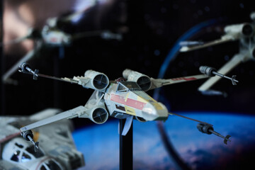 Naklejka premium A fleet of X-wing fighter figures arranged in outer space setup in San Salvador, May 4 2025, celebrating Star Wars Day.