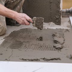 Hand Applying Tile Adhesive for Flooring Installation