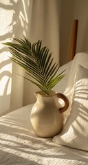 Sunlight streams through the window, illuminating a cream-colored pitcher with a palm leaf