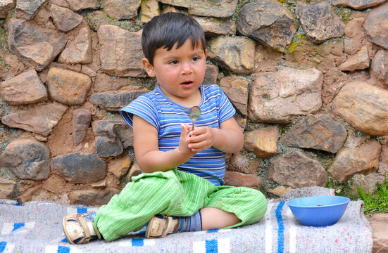 Little latin boy eating from a bowl.