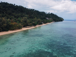 Fototapeta premium Stunning aerial view of a pristine beach meeting a lush rainforest on the tropical island of Koh Ngai, Thailand, offering a serene escape