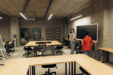 Modern Office Collaboration with Two Women Discussing in a Minimalist Workspace