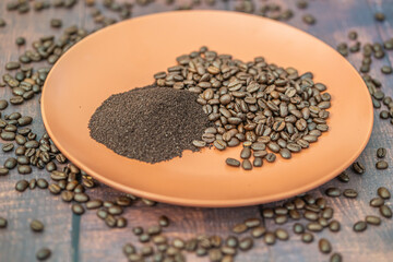 Fresh organic raw coffee beans and ground coffee on plate