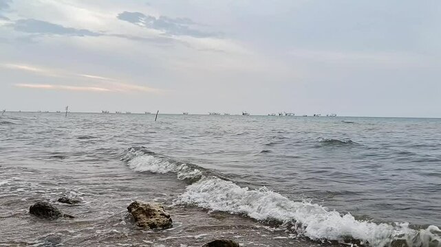 Overcast Coastal View with Active Fishing Fleet on the Horizon