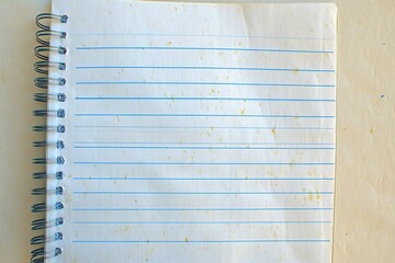 Lined notebook page with faint yellow spots