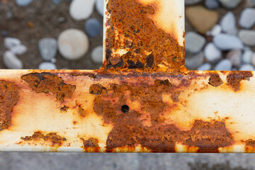A rusted metal beam with a hole in it