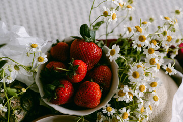 Fresh strawberries and chamomile flowers