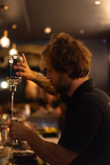 A bartender makes cocktails in a night bar