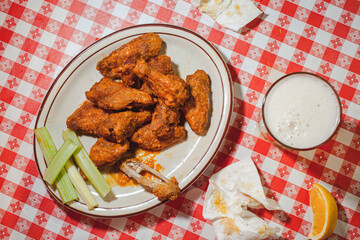 Plate of chicken wings on checkered table cloth
