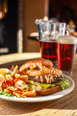 Burger with onion rings on plate with beer vertical