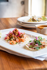 Plates of tacos on table with sauce