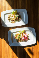 Overhead view of two plates of tacos