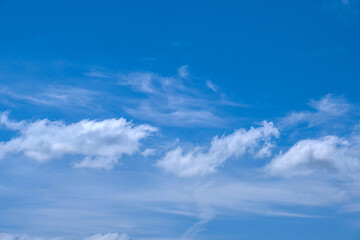 white cumulus clouds in blue sky.	