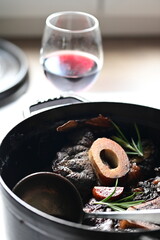 Family Meal Background – Braised Meat with Bone in Pot, Red Wine Sauce, Light Rustic Setting