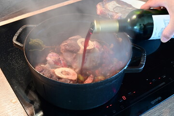 Close-Up of Deglazing Saut&eacute;ed Vegetables with Red Wine in Black Pot &ndash; Home Cooking Background
