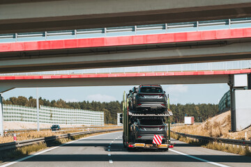 Car transporter carrying hybrid SUVs down the road