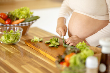 Pregnant Asian woman cooking healthy food at home