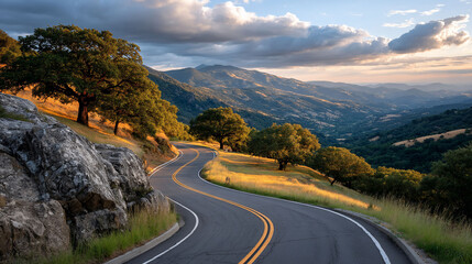 Scenic winding road cutting through rolling hills under a cloudy sky at sunset