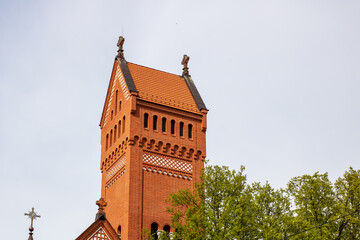 A tall brick tower that features a cross elegantly positioned on its top
