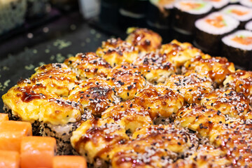 There are a very wide variety of different types of sushi on the table