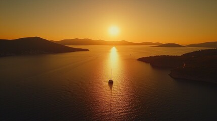 Beautiful sunset over calm waters with a sailboat near coastal hills in a serene landscape