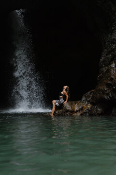 Woman practising yoga in front of waterfall on the island of Bali