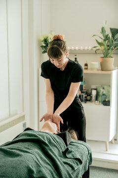 Young woman massagist making massage to her client