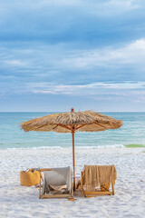beautiful tranquil white sand beach with two beach chair and thatched umbrella with copy space. romantic summer vacation at tropical private island for luxury sea resort advertising background.