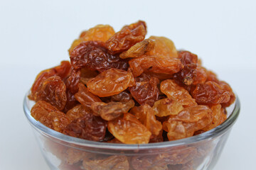 Pile of raisin in a transparent bowl, isolated on white background