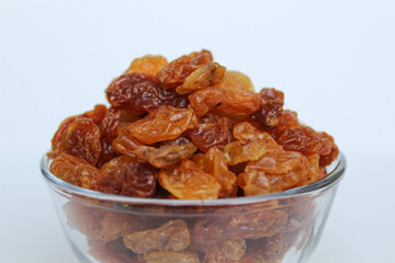 Pile of raisin in a transparent bowl, isolated on white background