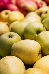 A bunch of apples can be observed stacked on top of each other carefully