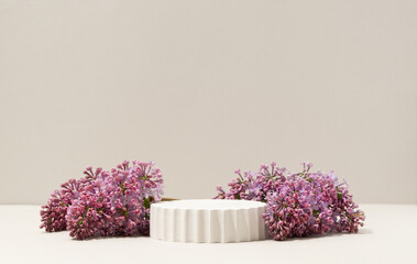 Beauty cosmetics product presentation podium made with white column surrounded by fresh lilac...