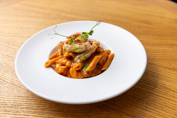 Juicy shrimps with penne pasta and creamy sauce served in a plate