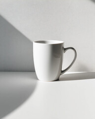 Obraz premium A white coffee cup sits on a table in front of a white wall