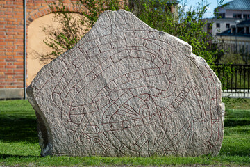 Runestone outside Uppsala Cathedral in Uppsala on a sunny spring day in Sweden. Uppsala was an important site already during Viking ages.