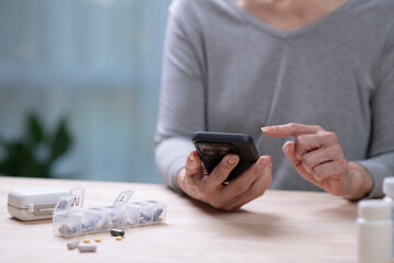 Middle aged woman checking medication reminder on phone.