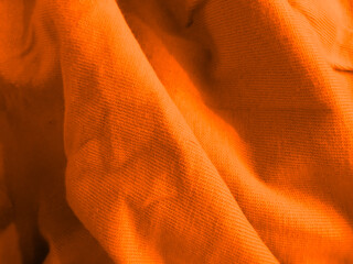Textured orange material in a draped arrangement.