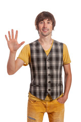 Smiling young man in plaid vest greets warmly against a simple backdrop