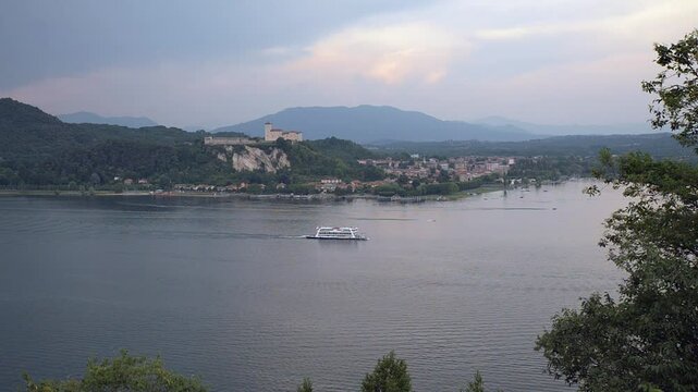 Tourist ferry on the lake. Large lake in northern Italy, lake Maggiore and the the town of Angera with the castle and the small port (right), view from the town of Arena. Overhead view in summer