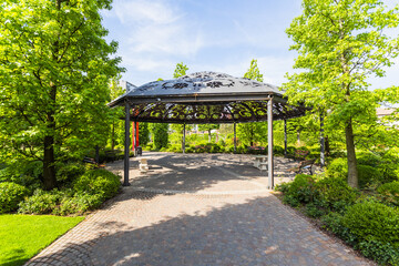 Inviting Park Pavilion with Stone Table and Benches in Urban Garden