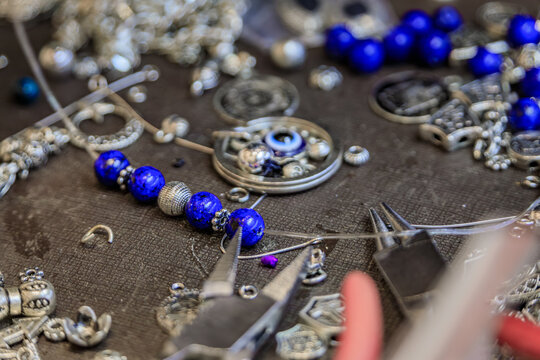Jeweler s workspace with lapis lazuli and silver beads, tools, for a custom made unique bracelet at the Grand Bazaar in Istanbul, Turkey