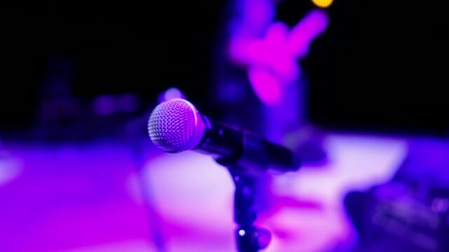 microphone in concert hall on stage and rock man playing guitar, soft blur neon night  lights  background.  Live music rock. mic Moscow Russia 01.28.2025