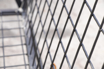 Black metal checkered bar fence on the street, fence