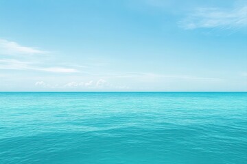 Obraz premium Tranquil expanse of turquoise water meeting a light blue sky dotted with fluffy white clouds