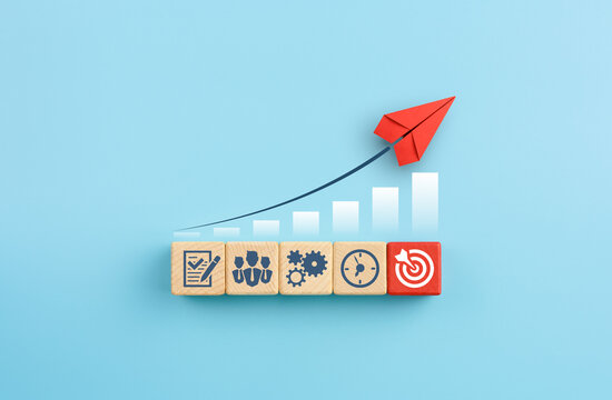 Red paper plane and wooden cubes with business strategy icons