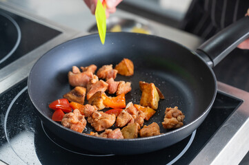 The chef fries pork in sweet and sour. 