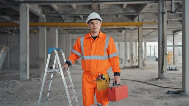 Construction worker in orange uniform with toolbox