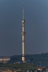 Fototapeta premium On the outskirts of the city stands a huge TV tower, pointing to the sky.