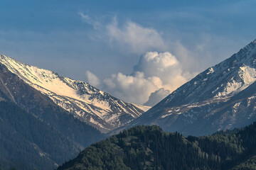 The peaks of the mountains are crowned with dense clouds.